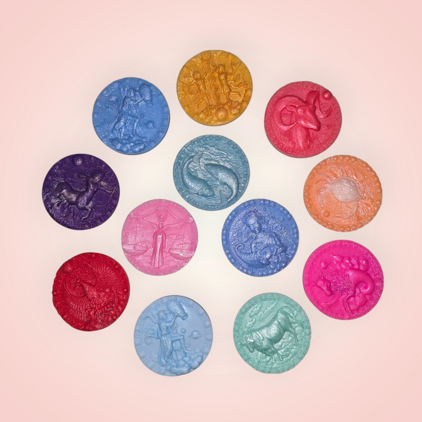 handmade round wax melts, each featuring a zodiac sign.