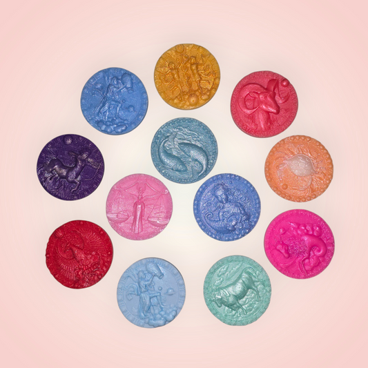 handmade round wax melts, each featuring a zodiac sign.